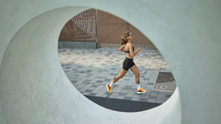 Woman running surrounded by contemporary architectural concrete circle outside