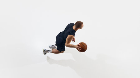 Basketball player mid-dribble in action shot with isolated background