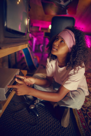 Girl using retro gaming console in cozy attic with pink neon light