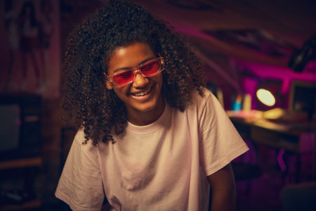 Teen girl smiling in pink glasses in retro attic room