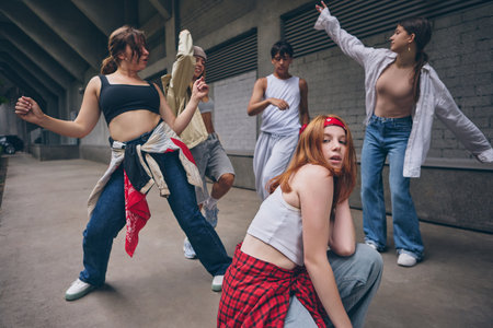 Redhead dancer posing in front with dramatic emotion during group street danceの写真素材