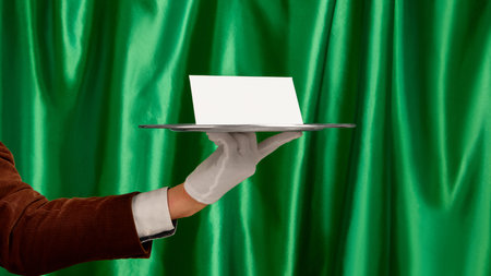 White paper on silver tray held by waiter hand in elegant presentation