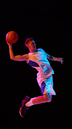 Basketball player airborne slam dunk in neon lighting full of intensity