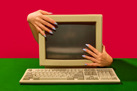 Vintage beige monitor embraced by female hands with playful nostalgic emotion