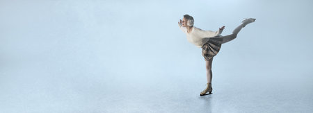 Female figure skater in white sweater and plaid skirt performing spin on icy stageの写真素材