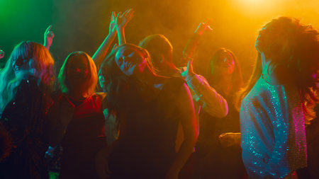 New Year Eve dancers illuminated by colorful lights and festive smokeの写真素材