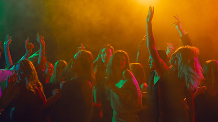 Joyful group celebrating Christmas night with dance and laughterの写真素材