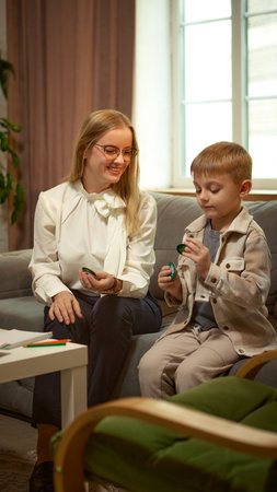 Psychologist smiling at child during developmental game therapy with positive emotionの写真素材