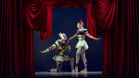 The art of connection. Mime kneeling before ballerina on stage with red curtain.