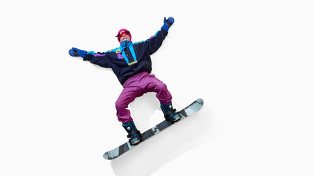 Cheerful female snowboarder lying on back with arms spread isolated on white backgroundの写真素材