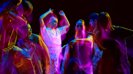 Street dancers moving in bright motion blur lightsの写真素材