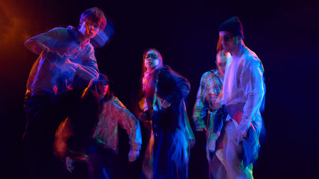 Dance group under neon lights captured with motion blurの写真素材