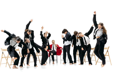 Business group dancing energetically around seated red-jacket leader expressing strong emotional contrastの写真素材