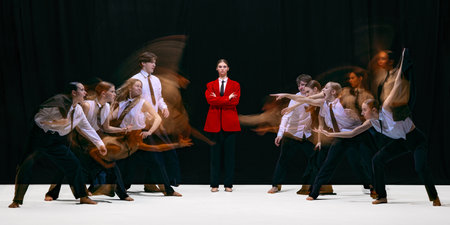 Leader in red jacket facing two opposing groups moving toward each other with motion blur