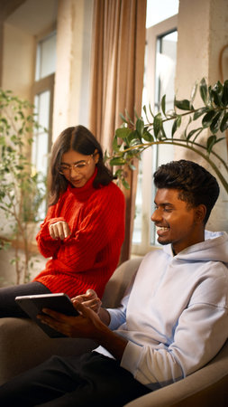 Two coworkers reviewing content on tablet in modern coworking lounge.