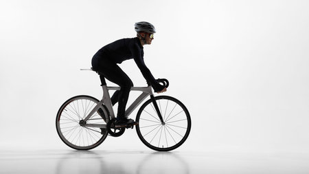 Professional cyclist riding road bike in studio isolated on white background.の写真素材
