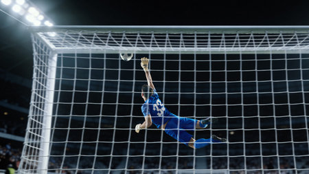 Soccer goalkeeper reaching ball near crossbar during match action.の写真素材