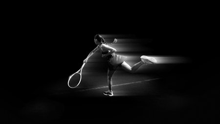 Cinematic composition. Female tennis athlete balancing after fast return on court.