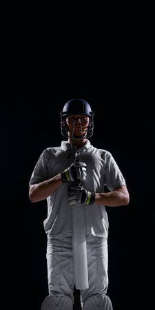 Front view cricket player holding bat vertically with intense focus.の写真素材