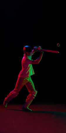 Cricket player hitting ball under red and green neon lighting