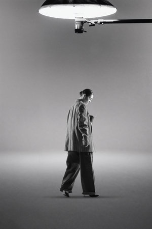 Digital artwork of woman walking under studio spotlight.の写真素材