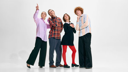 Creative business team looking up and pointing isolated on white.