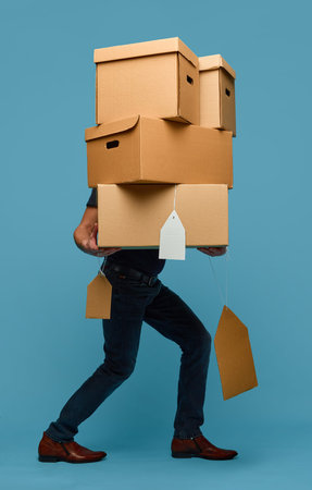 Retail sale concept man carrying stack of cardboard boxes