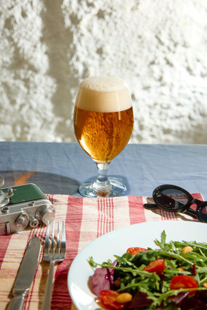 Craft beer glass with fresh salad lunch outdoor table