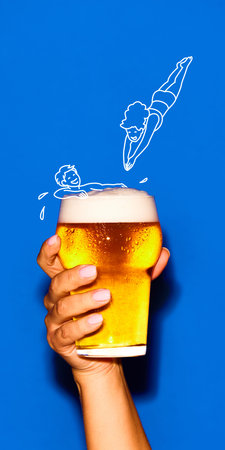 Glass of beer with playful cartoon swimmers diving into foam.の写真素材