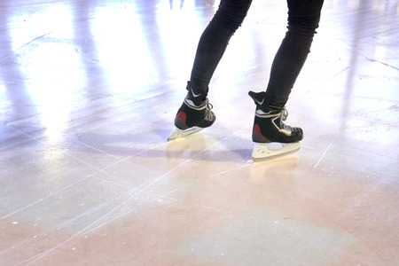 Legs of a woman skating on an ice rink
