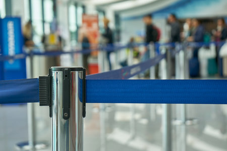 Attachment of the retractable belt. Portable tape barrier. Fence strip Blue Color. Airport Scene With Passengers Waiting For Boardingの写真素材