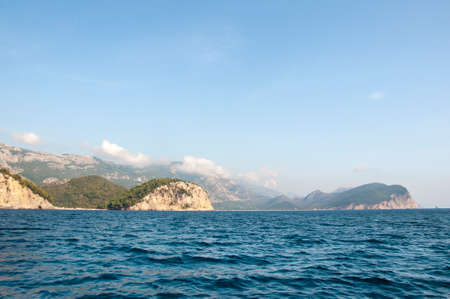 tall sharp cliff shooted from the water montenegroadriatic sea trees on topの写真素材