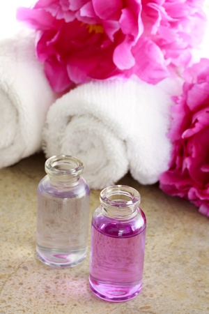 Aroma oil with pink peony flowers and towelsの写真素材