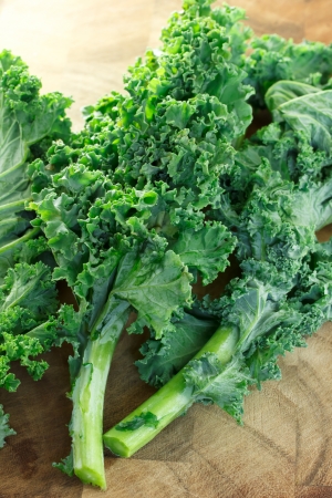 Fresh kale on wooden cutting boardの写真素材