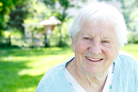 Happy senior lady smiling in spring gardenの写真素材