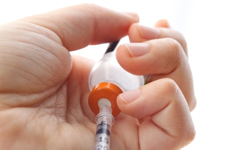 Hand holding syringe and vialの写真素材