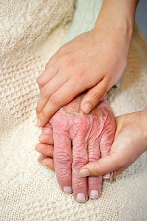 Old and Young Hands on White Blanketの写真素材