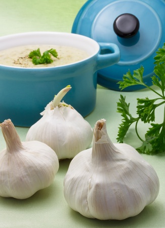Garlic with creamy soup in blue potの写真素材