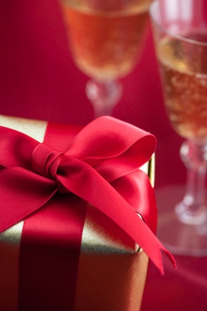Gift box with champagne on red backgroundの写真素材