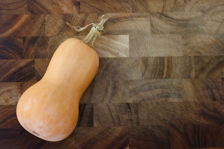 Butter nut squash on wooden cutting boardの写真素材
