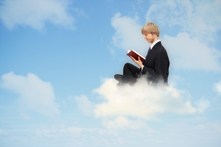Business man reading book on the cloudの写真素材