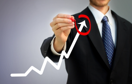 Businessman highlighting business growth on a graph Businessman highlighting business growth on a graph