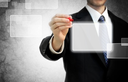 Business man with pen in front of touch screenの写真素材