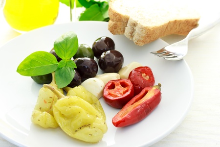 Assorted Olives and Peppers on a White Plateの写真素材
