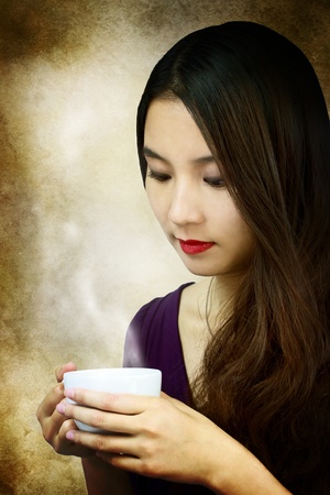 Beautiful young woman holding a coffee cup の写真素材