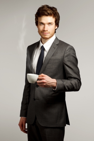 Young Business Man Drinking a Cup of Coffee or Teaの写真素材