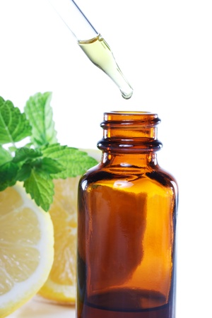 Herbal medicine dropper bottle with mint leaves and lemonの写真素材