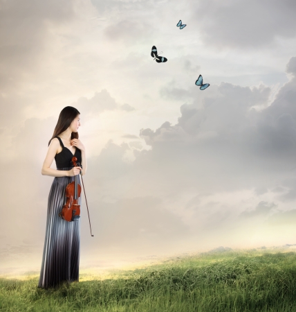 Violin Player on a Mountain Top  with butterflies の写真素材