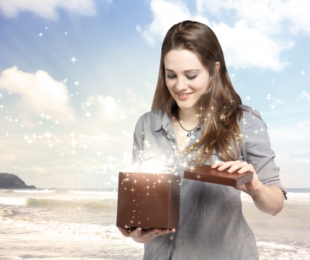 Happy Young Woman Opening a Gift Boxの写真素材