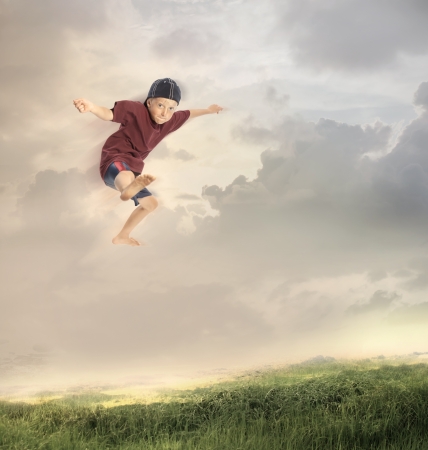 Happy Young Boy Jumping in the fieldの写真素材